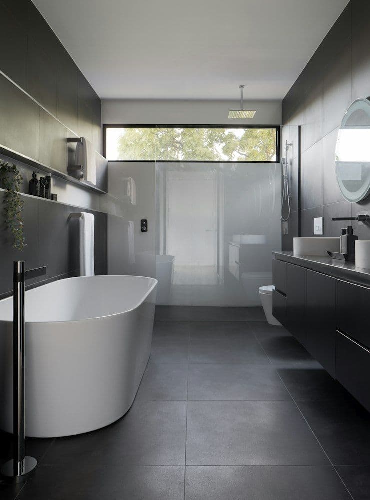 Dark modern bathroom with freestanding tub