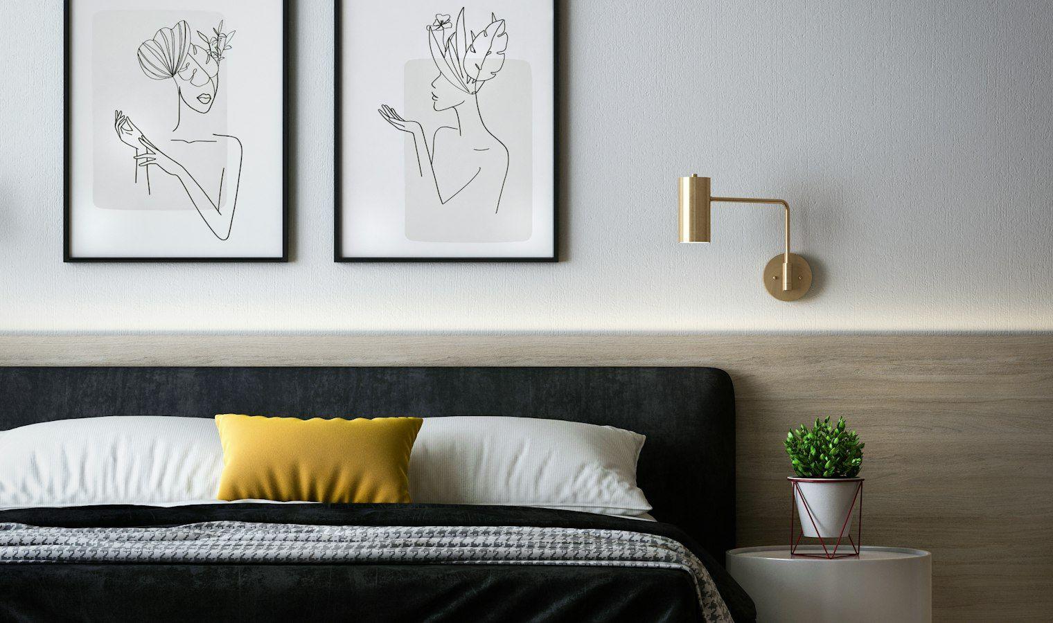 Bedroom with black headboard and minimal artwork