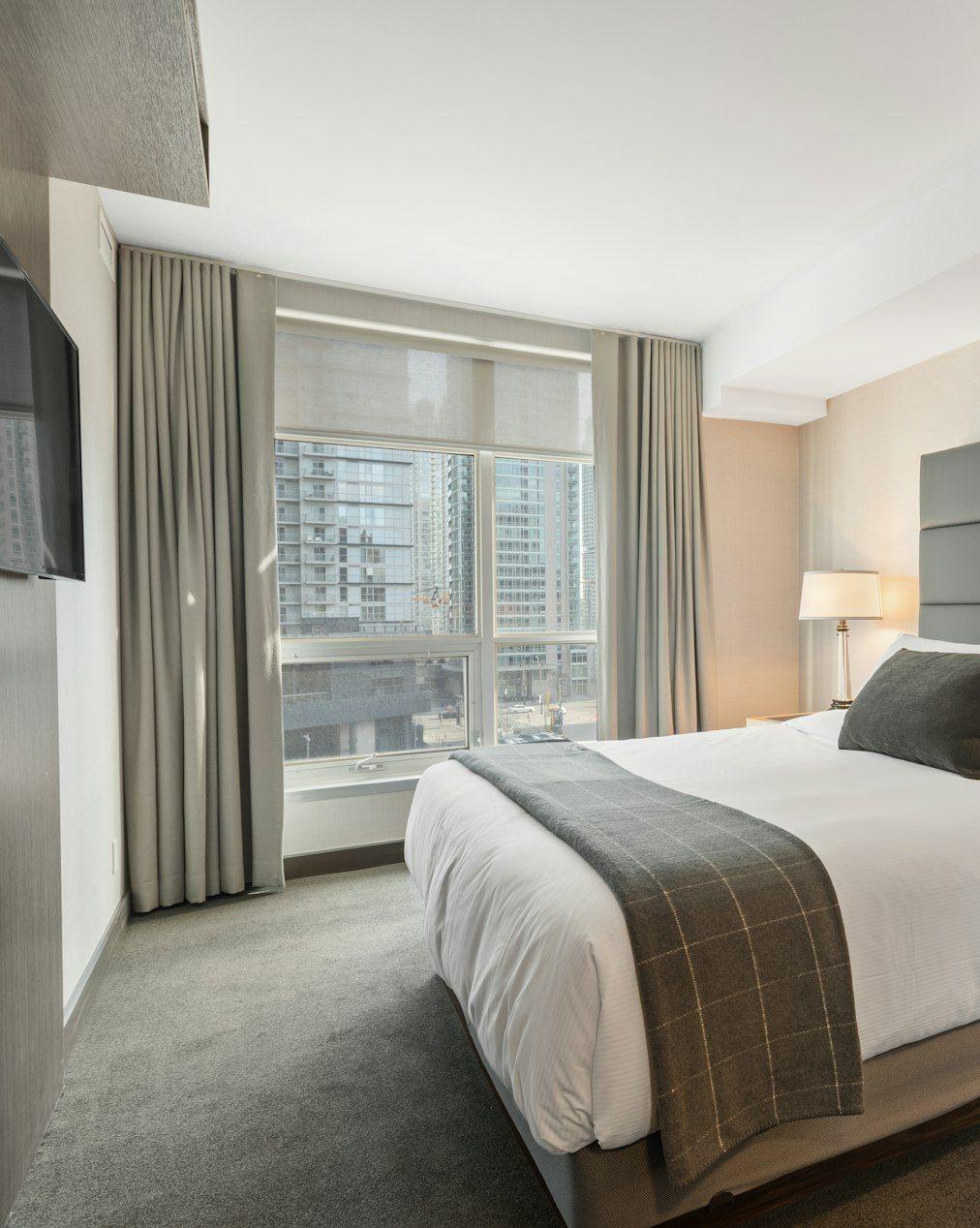 Bedroom with tall grey headboard and crisp linen