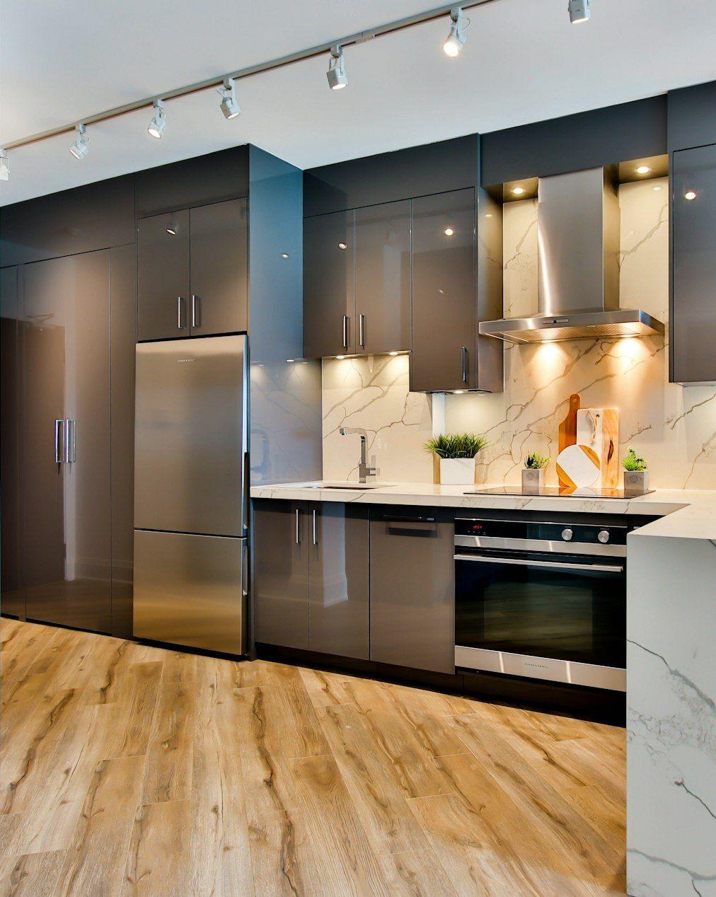 Dark minimal kitchen with marble island and track lights