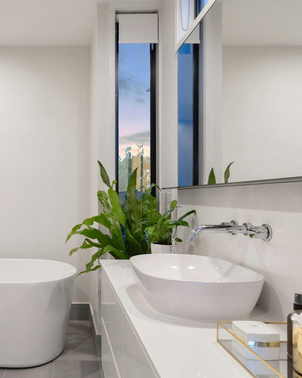 White bathroom with freestanding tub and plants