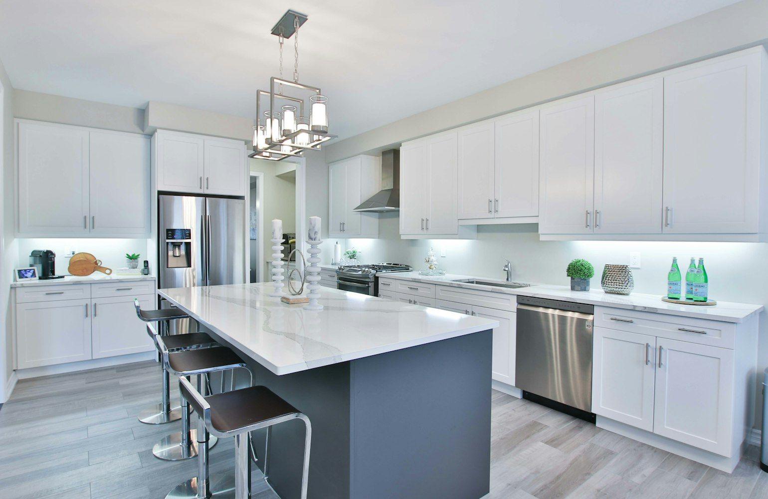 White kitchen with marble island and pendant lights