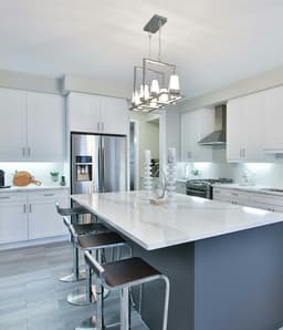 White kitchen with marble island and pendant lights