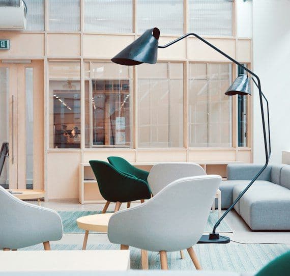 Bright studio office with white chairs and floor lamp