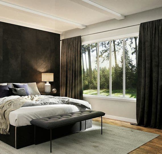 Dark bedroom with black headboard and window seat